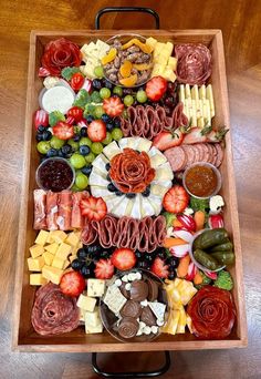 a wooden platter filled with lots of different types of meats and cheeses