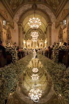 the inside of a building with flowers and chandeliers