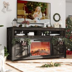 a living room decorated for christmas with a fireplace and large screen tv on the wall