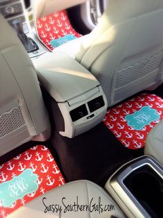 the interior of a car with red and white anchor mats on the floor, steering wheel cover and dash mat