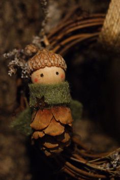 a small pine cone with a little snowman figurine on it's head