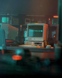 an old computer monitor sitting on top of a desk next to other electronic equipment in a room