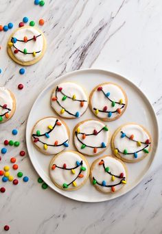 cookies decorated with icing and colored sprinkles on a white plate