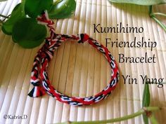 a close up of a bracelet on a bamboo mat with plants and leaves in the background