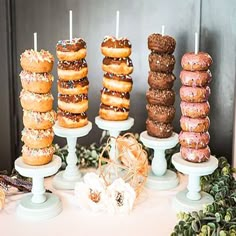 there are many donuts on the table and one is stacked high with candles in it