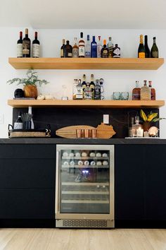 a kitchen with an oven and shelves filled with bottles