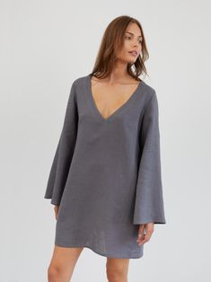 UMA is a short and flowy linen mini dress with a relaxed, slightly oversized fit. It features a deep V-neckline and 70s-inspired wide, flowing bell sleeves. DETAILS - Deep V-neckline - Wide, flowing bell sleeves - A-line silhouette - Mini length - Side seam pockets COLOR - Light Grey (featured color) - Multiple colors available in dropdown menu above - See all color options & order fabric samples here: https://www.etsy.com/listing/586569696/linen-fabric-samples SIZING & FIT - Relaxed fit - The m Dress Bell Sleeves, Linen Tunic Dress, Flare Sleeve Dress, Linen Mini Dress, Trapeze Dress, Dress With Sleeves, Linen Tunic, Dress Tunic, 70s Inspired