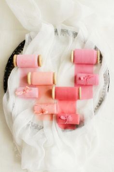 four popsicles on a plate with some pink and yellow sticks sticking out of them