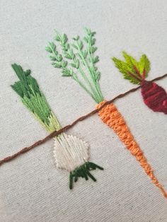 the carrots are being stitched together with different colors and designs on linen material