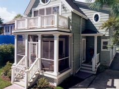 the house is painted gray and has white trim on the porch, windows, and balconies