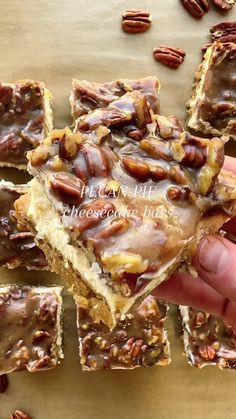 pecan bars with chocolate frosting and pecans in the middle being held by someone