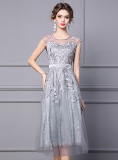 Generate an air of sophisticated charm in this mother of the bride dress, where classic style meets contemporary design! Glide through the wedding venue in this stunning grey creation, featuring a bodice beautifully adorned with intricate floral appliques. The sheer neckline and sleeveless cut add a touch of modern allure, while the embellished waistband offers a flattering silhouette and a subtle contrast against the flowing skirt. Perfect for a mother who treasures elegance, this dress promises a look of timeless beauty, making it an impeccable choice for the occasion. Itnot just a dresst's a symbol of the joy and love that marks the celebration. Gray Fitted Evening Dress For Bridesmaid, Elegant Floral Mother Of The Bride Dress For Wedding, Gray Fitted Bridesmaid Evening Dress, Elegant Gray Tulle Evening Dress, Gray Floor-length Mother Of The Bride Dress, Fitted Gray Evening Dress For Mother Of The Bride, Elegant Gray Mother Of The Bride Dress, Elegant Gray Dress For Mother Of The Bride, Silver Floral Embroidered Wedding Dress