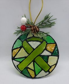 a stained glass ornament with a green ribbon