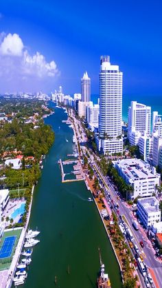 an aerial view of a city and the ocean with boats in the water near it