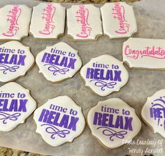 decorated cookies with time to relax and congratulations written in pink, purple and white icing