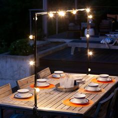 an outdoor dining table with lights on it