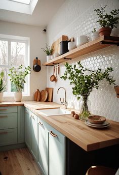 a kitchen filled with lots of wooden counter top next to a window covered in potted plants