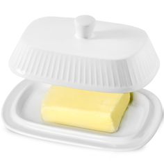 a piece of butter sitting on top of a white container with a lid over it