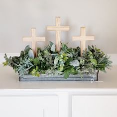 a table with crosses and greenery on it