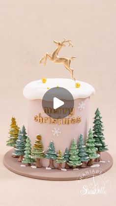 a christmas cake decorated with trees and reindeer on top is featured in the video'merry christmas '