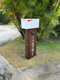 a mailbox sitting in the grass next to a tree