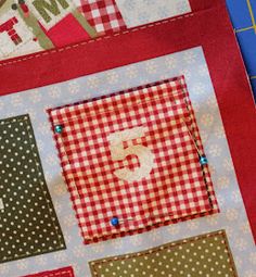 a red and white patchwork quilt on top of a cutting board