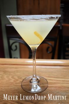 a lemon drop martini sitting on top of a wooden table