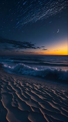 the night sky is lit up by stars and clouds over an ocean beach with waves