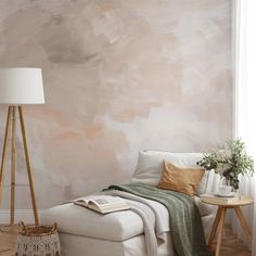 a white couch sitting next to a lamp on top of a hard wood floor