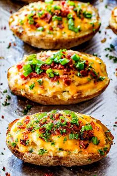 baked potato skins with cheese and green onions on a baking sheet, ready to be eaten