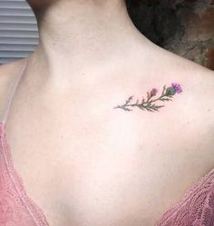 a woman with a small tattoo on her chest and flowers in the middle of her chest