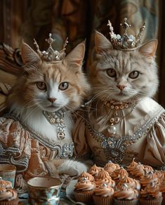 two cats wearing tiaras sit next to cupcakes