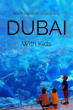 two children looking at an aquarium with the words best things to do when visiting dubai with kids