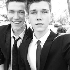 two young men wearing suits and ties posing for a photo together in black and white