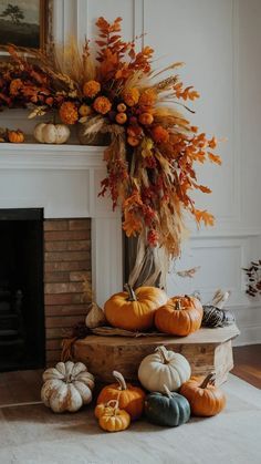 an arrangement of pumpkins and gourds in front of a fireplace