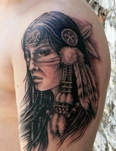 a man's arm with a native american tattoo design on the back of his shoulder