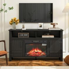 a living room with a fire place in the center and a television on top of it