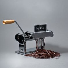 a pile of brown paper next to an old fashioned toaster with a wooden handle