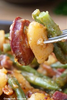 a fork with some food on it that is being held up to the camera,