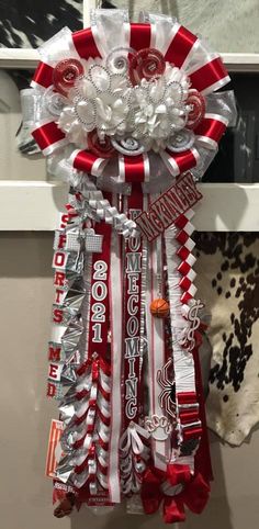 a red and white ribbon with some candy in it's center is hanging on the wall