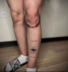 a woman's legs with tattoos on them and an eye in the middle of her leg