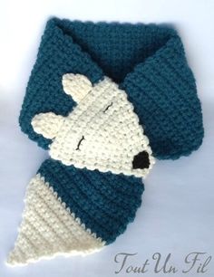 a crocheted scarf with a white and blue dog wearing a knitted hat