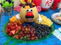 there is a plate with fruit on it and a clown face made out of fruits