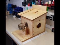 a wooden birdhouse sitting on top of a counter next to scissors and other tools