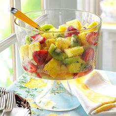 a fruit salad in a glass bowl on a table