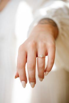 a close up of a person's hand with a wedding ring on their finger