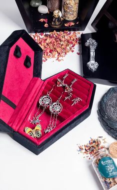 an assortment of jewelry is displayed on a white surface with other items in the background