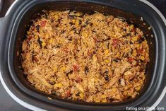 a crock pot filled with rice and vegetables