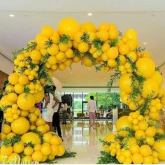 an archway made out of lemons and greenery in the middle of a lobby