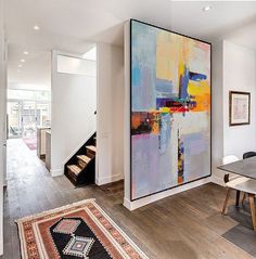 an abstract painting hangs in the dining room